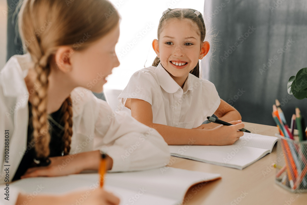 Two pupils collaborating during lesson in classroom Two pupils collaborating during lesson in classroom