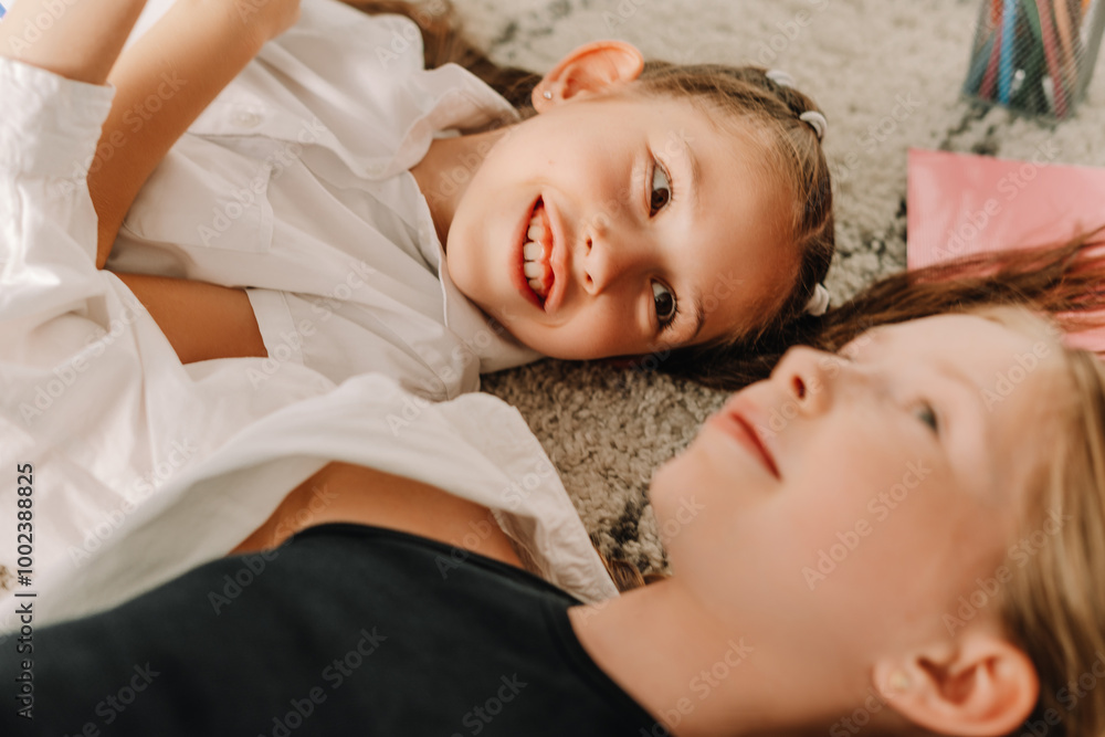 Two sisters lying on carpet sharing secrets Two sisters lying on carpet sharing secrets