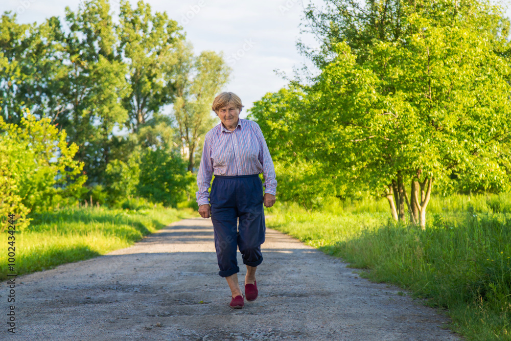 Fototapeta premium Old woman on a walk. Selective focus.
