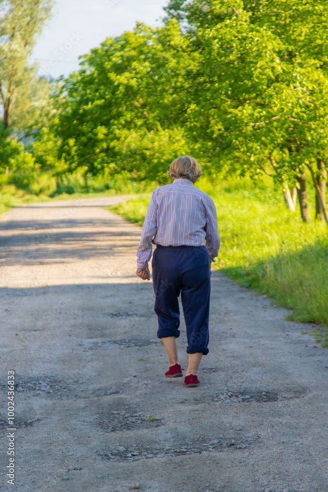 Fototapeta premium Old woman on a walk. Selective focus.
