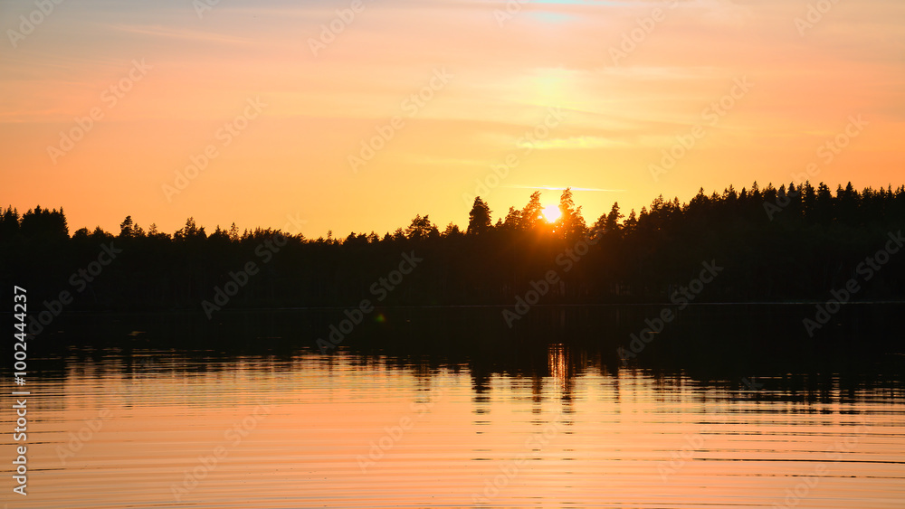 Obraz premium Sunset with warm colors on a Swedish lake in Smalland. Romantic evening atmosphere