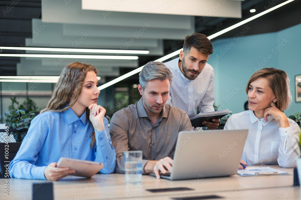Successful businesspeople working in a coworking space working with laptop discussing strategy and business plan in modern office. Successful businesspeople working in a coworking space working with laptop discussing strategy and business plan in modern office.