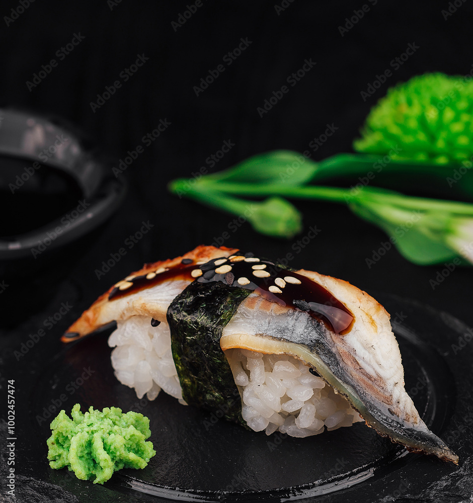 Unagi nigiri sushi with eel on black stone plate