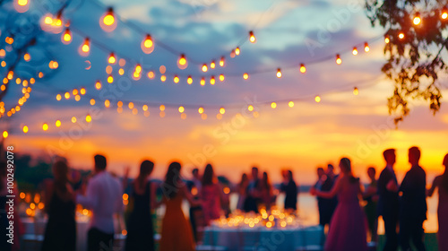 Blurred background of an elegant evening event with people dancing and socializing in the foreground In the foreground, blurry figures can be seen celebrating at a festive party 