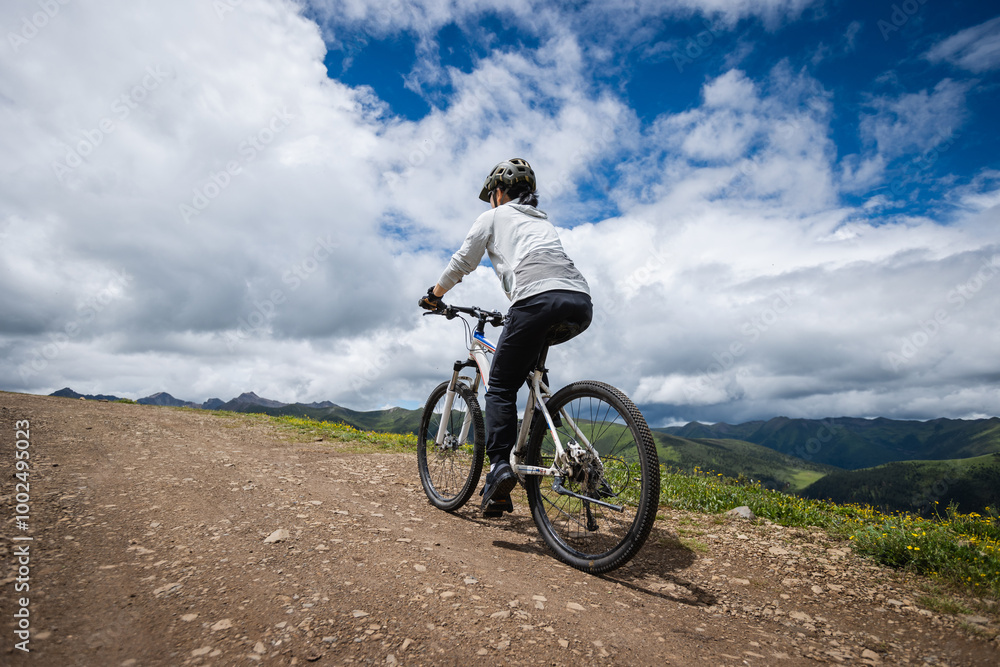 Asian woman riding mountain bike on beautiful mountain top Asian woman riding mountain bike on beautiful mountain top
