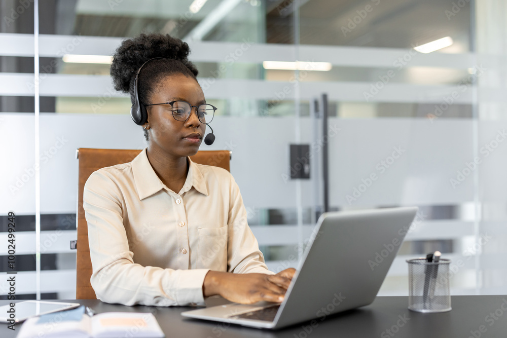 Confident woman wearing headset using laptop in modern office setting. Focused on customer service with phone support, displaying professionalism and dedication in workplace environment. Confident woman wearing headset using laptop in modern office setting. Focused on customer service with phone support, displaying professionalism and dedication in workplace environment.