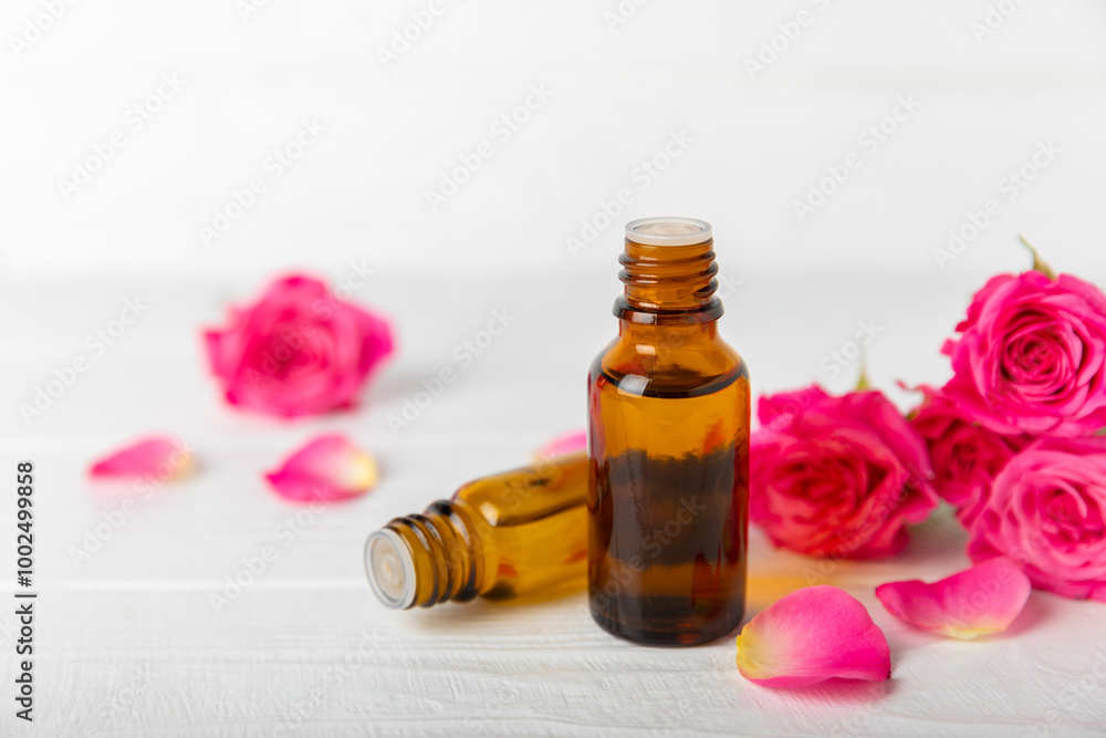 Rose essential oil on a textured background.Roses and a bottle of rose perfumed water.Aromatherapy treatment. Beauty concept. Spa procedure.Natural organic oil.Anti-stress,detox relax.Place for text Rose essential oil on a textured background.Roses and a bottle of rose perfumed water.Aromatherapy treatment. Beauty concept. Spa procedure.Natural organic oil.Anti-stress,detox relax.Place for text