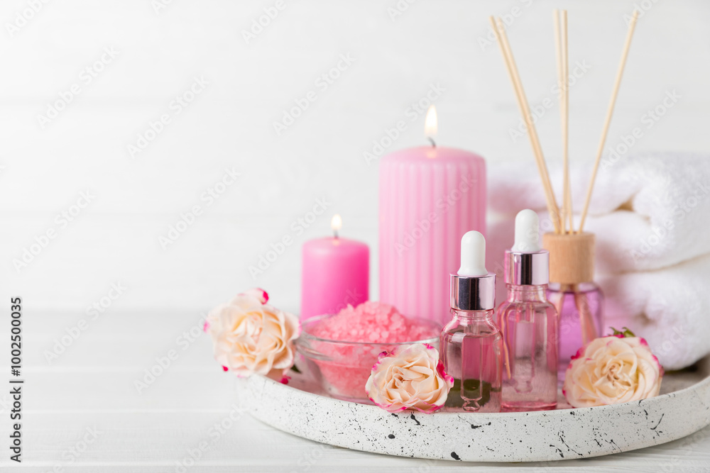 Rose essential oil on a textured background.Roses and a bottle of rose perfumed water.Aromatherapy treatment. Beauty concept. Spa procedure.Natural organic oil.Anti-stress,detox relax.Place for text Rose essential oil on a textured background.Roses and a bottle of rose perfumed water.Aromatherapy treatment. Beauty concept. Spa procedure.Natural organic oil.Anti-stress,detox relax.Place for text