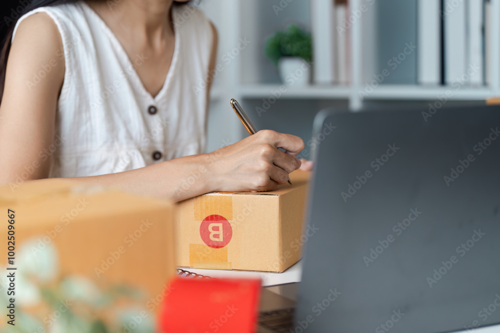 Small Business Owner Preparing Packages for Online Sales with Laptop and Shipping Boxes Small Business Owner Preparing Packages for Online Sales with Laptop and Shipping Boxes