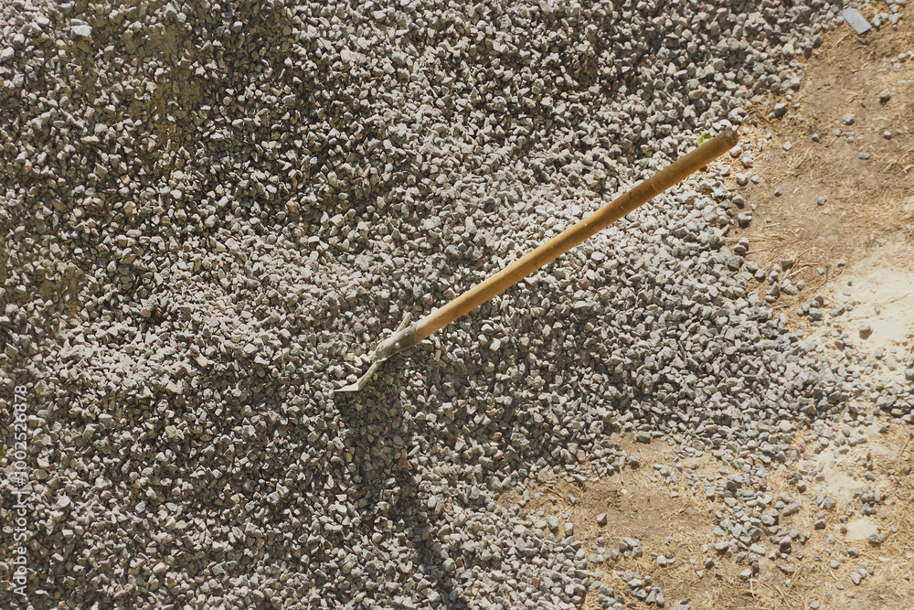 A shovel is embedded in a pile of gravel at a construction site, working with gravel at a construction site, loading gravel, close-up. A shovel is embedded in a pile of gravel at a construction site, working with gravel at a construction site, loading gravel, close-up.