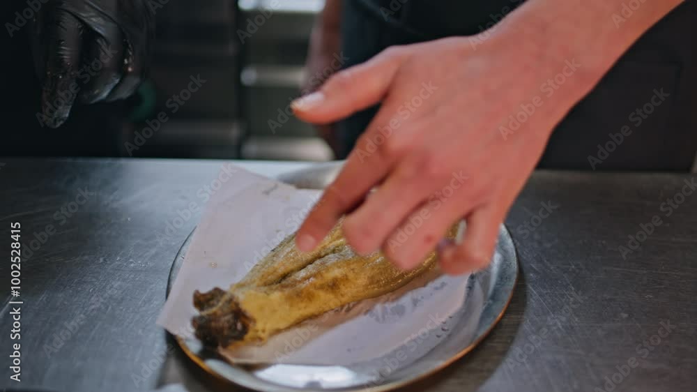 Hands touching prepared dish on plate at kitchen workspace closeup. Unknown chef Hands touching prepared dish on plate at kitchen workspace closeup. Unknown chef
