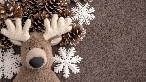 Cozy Christmas flat lay featuring a plush moose surrounded by snowflakes and pinecones for a festive winter theme photo