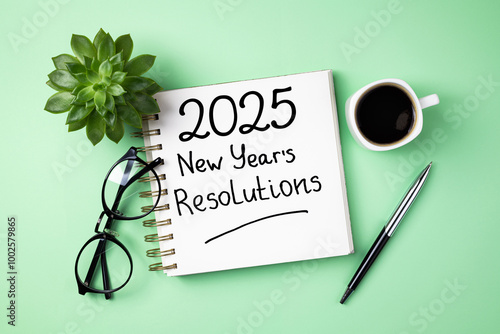 New year resolutions 2025 on desk. 2025 resolutions list with notebook, coffee cup on pink table. Goals, resolutions, plan, action, checklist concept. New Year 2025 template, copy space photo