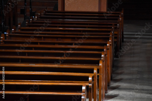 Shiny long wooden church pew in alignment inside a church photo