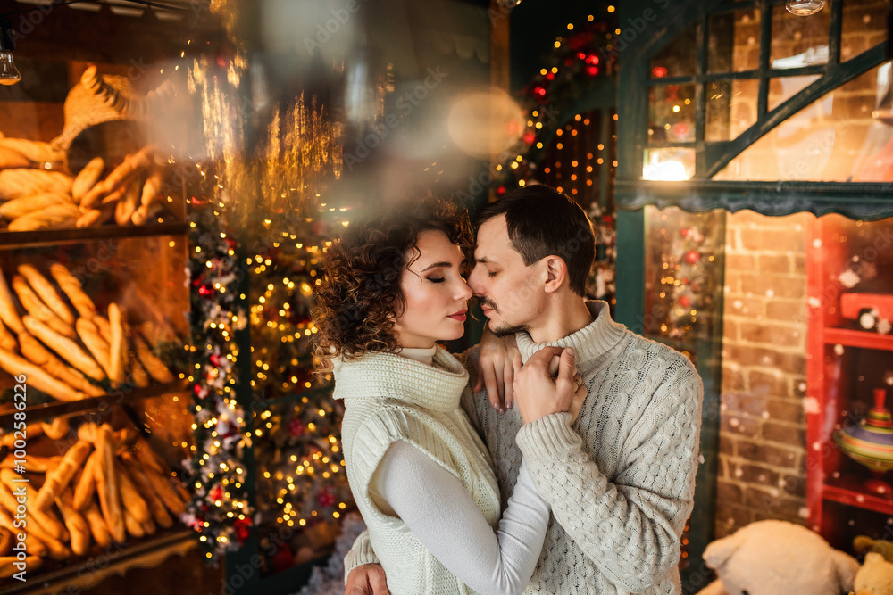 Fototapeta premium couple in love hugging on a background of lights and a Christmas tree