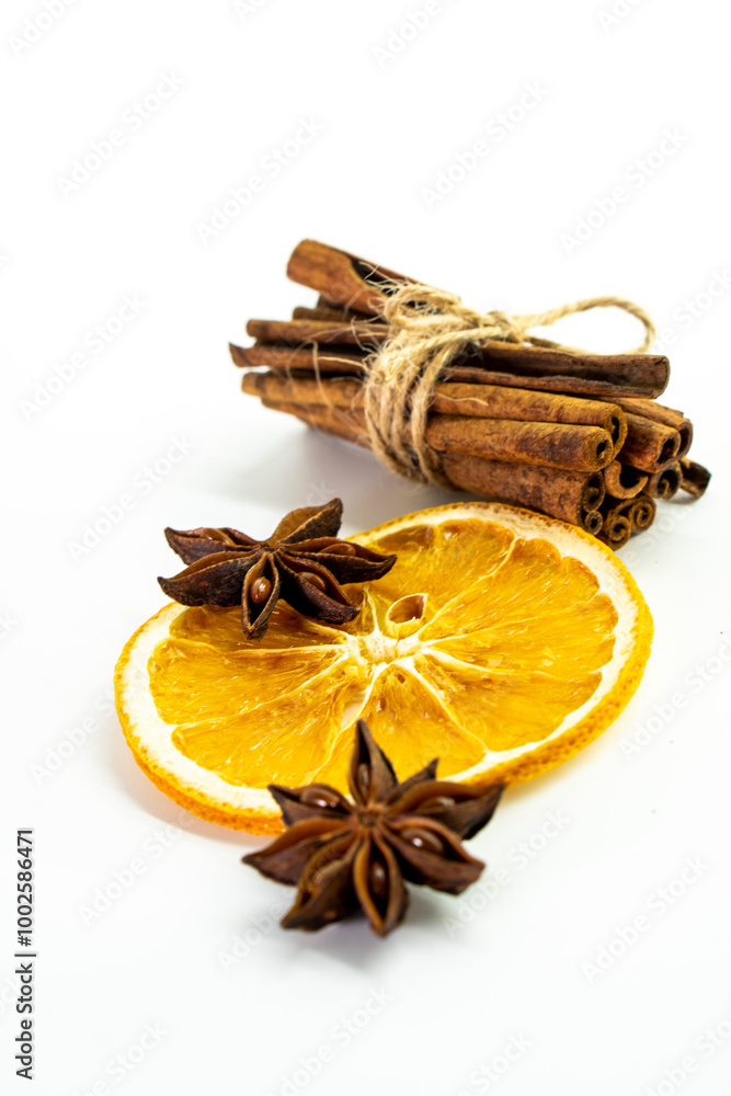 Cut orange and different spices on white background. Traditional festive winter beverage.Cinnamon, dried orange, anise and cloves Cut orange and different spices on white background. Traditional festive winter beverage.Cinnamon, dried orange, anise and cloves
