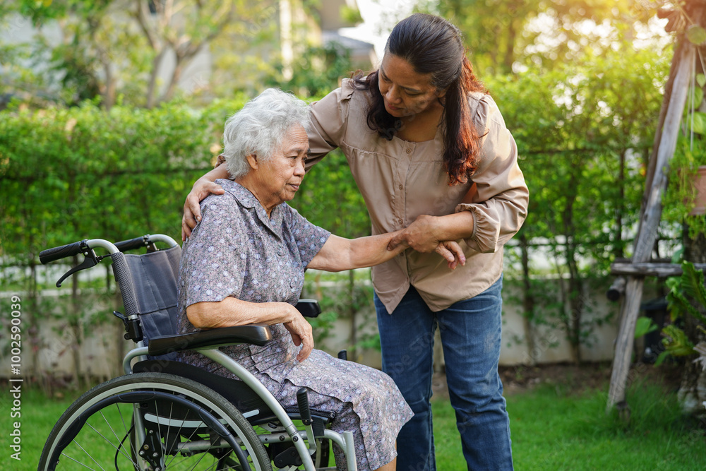 Caregiver help Asian elderly woman disability patient sitting on wheelchair in park. Caregiver help Asian elderly woman disability patient sitting on wheelchair in park.