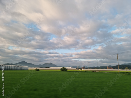  It is a rural landscape with a nice cloudy sky.