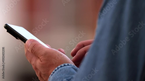 The fingers of a person using an unidentifiable mobile phone