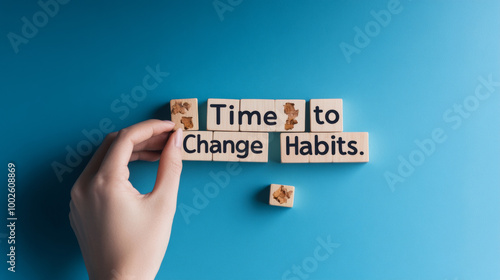 A psychologist's hand reaches for wooden blocks spelling "Time to Change Habits." The blocks stand out against a calming blue backdrop, suggesting a fresh start and the potential for positive change.