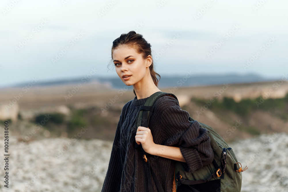 adventurous woman overlooking vast ocean from hilltop with backpack adventurous woman overlooking vast ocean from hilltop with backpack