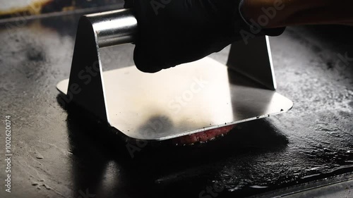 smashing hamburger patty ball in a hot flat griddle, smashing or pressing meat patty, smash burger