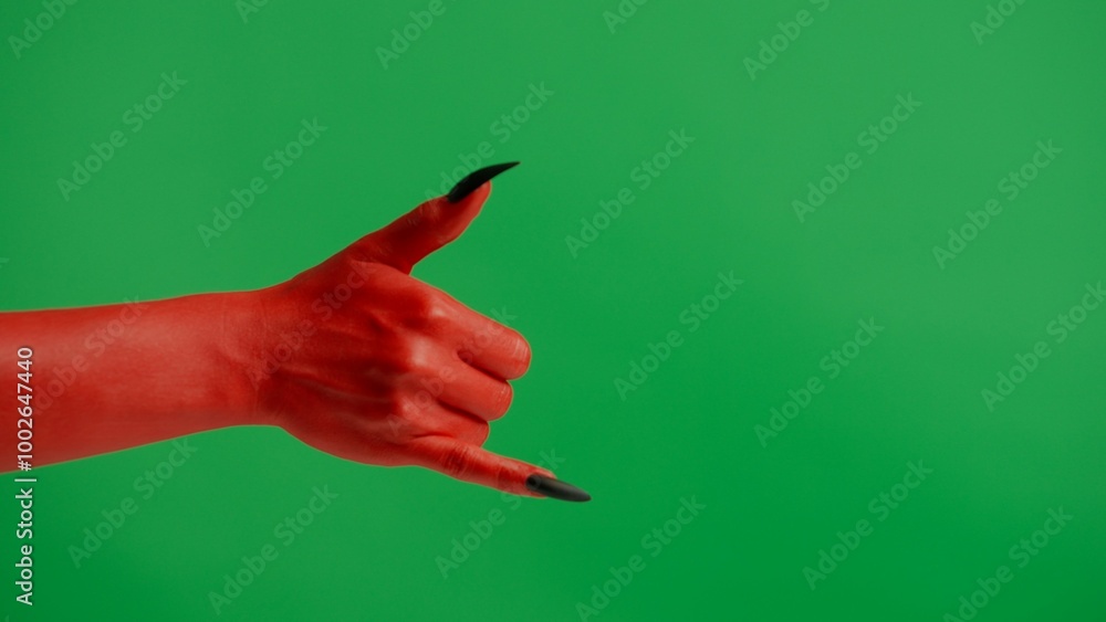 Creepy halloween devil monster hand in red paint with black nails shows call me a gesture, isolated on chroma key green screen background, workspace mockup. Creepy halloween devil monster hand in red paint with black nails shows call me a gesture, isolated on chroma key green screen background, workspace mockup.