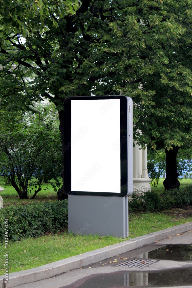 There is a billboard in the park with empty space for advertising. There is a billboard in the park with empty space for advertising.