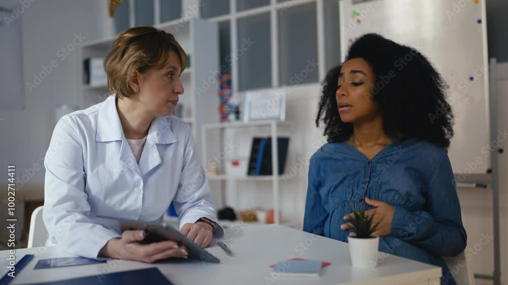 Gynecologist showing ultrasound image to sad pregnant woman, risk of pathology Gynecologist showing ultrasound image to sad pregnant woman, risk of pathology