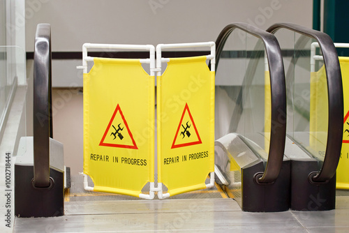 Obraz na płótnie Repair in progress sign displayed in front of an escalator or travelator in shopping center, maintenance work, public safety near the travelator. Warning barrier blocking escalator for maintenance w salonie