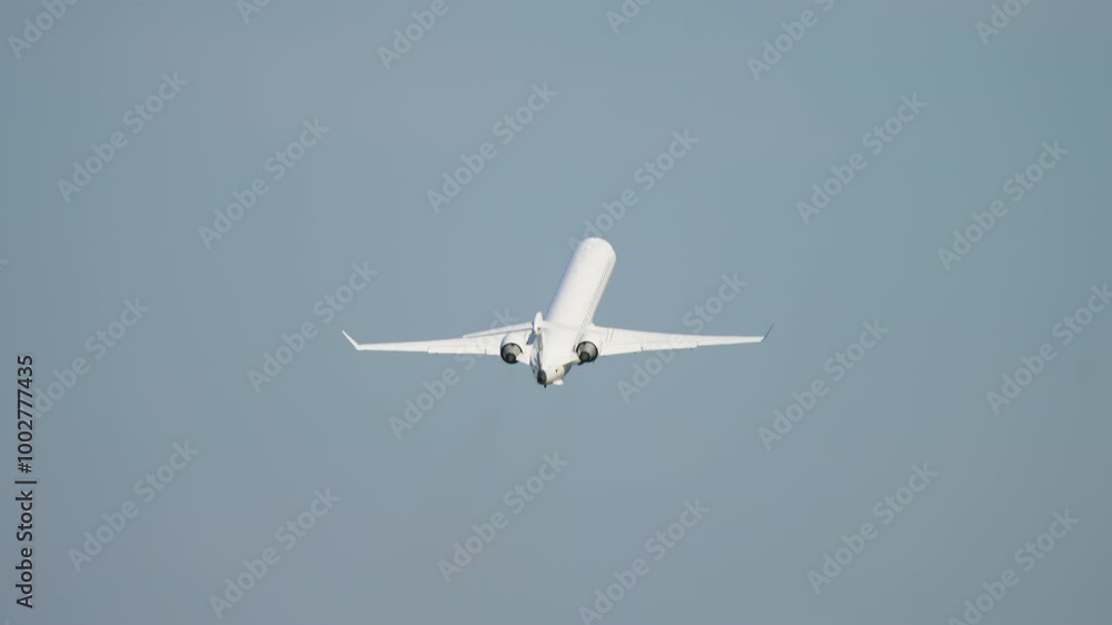 Airplane Performing Take of from Passenger Airport Against Clear Blue Sky During Daytime. Commercial airplane tilts sharply to side, showcasing its wingspan while flying against clear blue sky Airplane Performing Take of from Passenger Airport Against Clear Blue Sky During Daytime. Commercial airplane tilts sharply to side, showcasing its wingspan while flying against clear blue sky