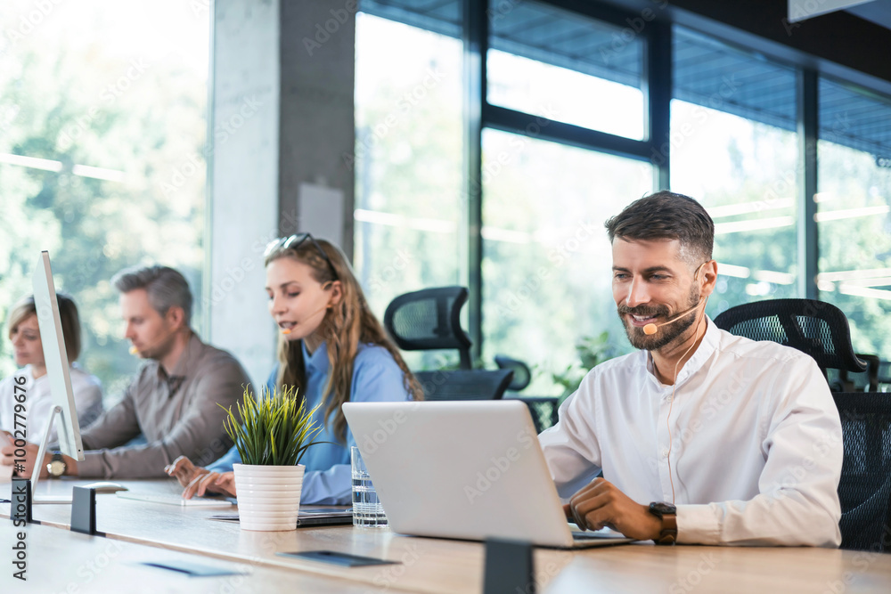 Portrait of call center worker accompanied by his team. Smiling customer support operator at work. Portrait of call center worker accompanied by his team. Smiling customer support operator at work.