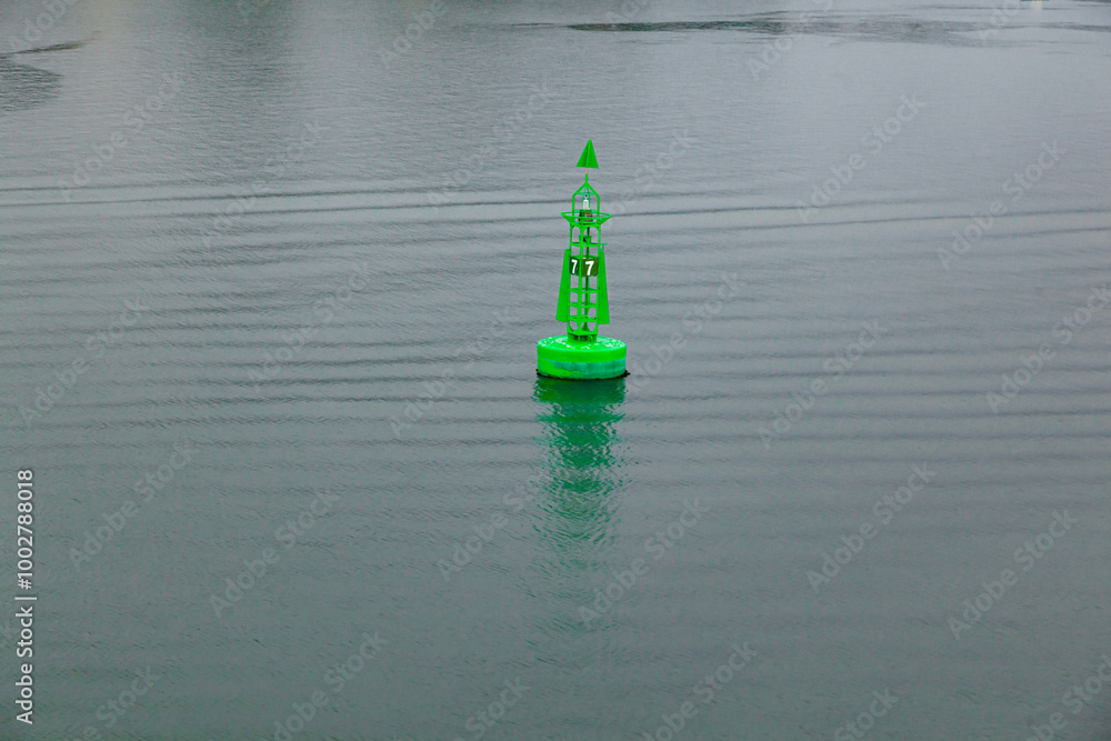 Green marine signal buoy in calm sea water. Green marine signal buoy in calm sea water.
