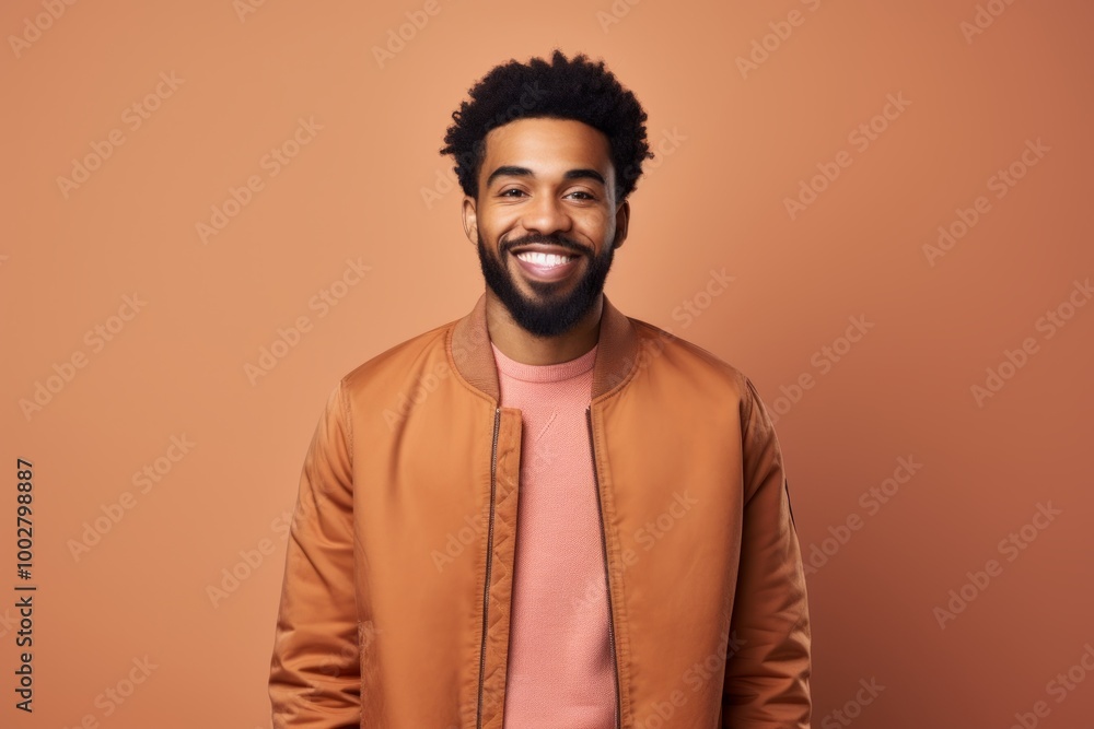 Portrait of a satisfied afro-american man in his 20s wearing a trendy bomber jacket over light wood minimalistic setup Portrait of a satisfied afro-american man in his 20s wearing a trendy bomber jacket over light wood minimalistic setup