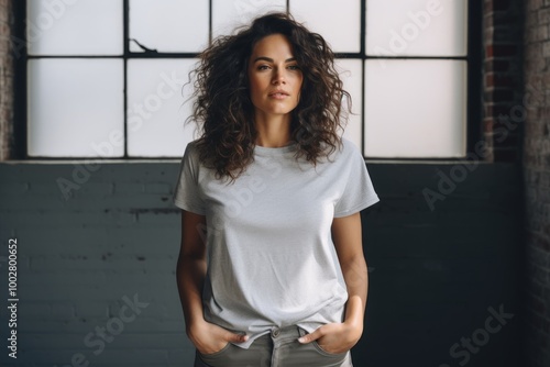 Portrait of a blissful woman in her 30s dressed in a casual t-shirt in empty modern loft background