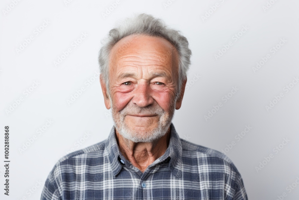 Portrait of a smiling man in his 70s wearing a comfy flannel shirt over plain white digital canvas Portrait of a smiling man in his 70s wearing a comfy flannel shirt over plain white digital canvas