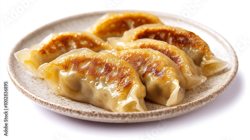 Delicious golden-brown pan-fried dumplings served on a plate, showcasing traditional Asian cuisine photo