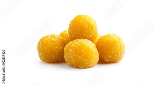 Sweet yellow balls of coconut and jaggery stacked on a white background, ready to enjoy any time