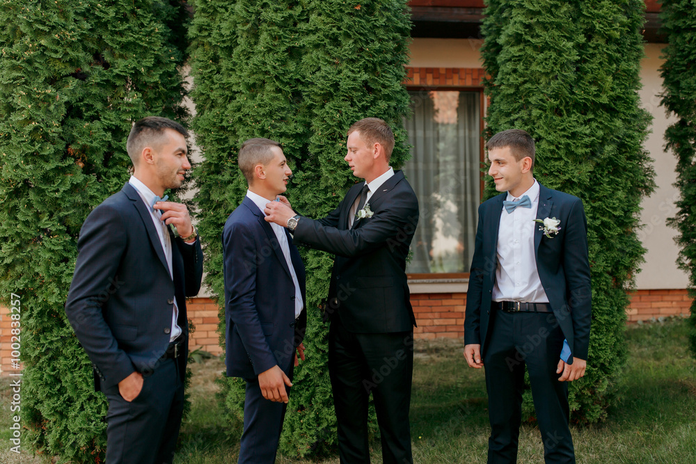 A group of men dressed in suits and ties are standing in front of a large tree. They are all smiling and seem to be enjoying each other's company