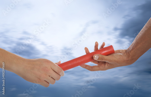 Quadro em tela Man passing relay baton to teammate outdoors, closeup