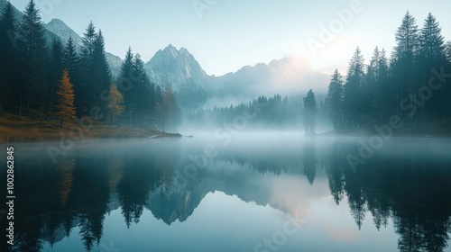 The calm lake is enveloped in fog on a serene morning, with trees and mountains reflecting perfectly on the water's surface, creating a peaceful atmosphere