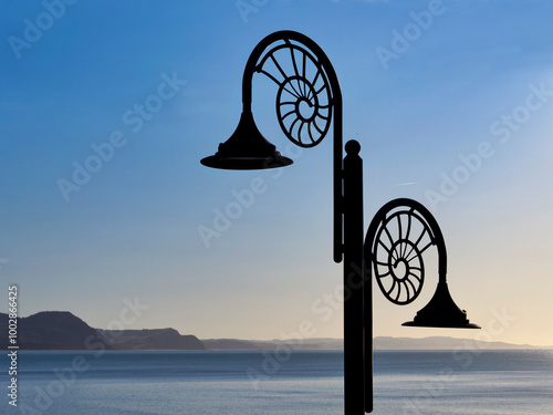 Nautilus-designed lamps along the seafront at Lyme Regis with Lyme bay and the jurassic coastline in the distance photo