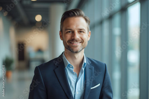 portrait of successful businessman consultant looking at camera and smiling inside modern office building