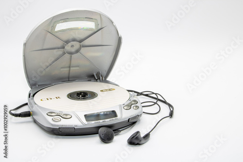 Close-up of a discman with the lid open with a CD and headphones isolated on white background