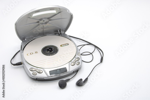Close-up of a discman with the lid open with a CD and headphones isolated on white background