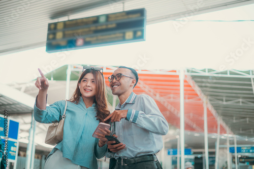 A couple, filled with excitement and joy, planning their exciting journey at the airport