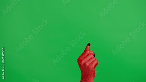 Creepy halloween devil monster hand in red paint with black nails flicking fingers, isolated on chroma key green screen background, workspace mockup.