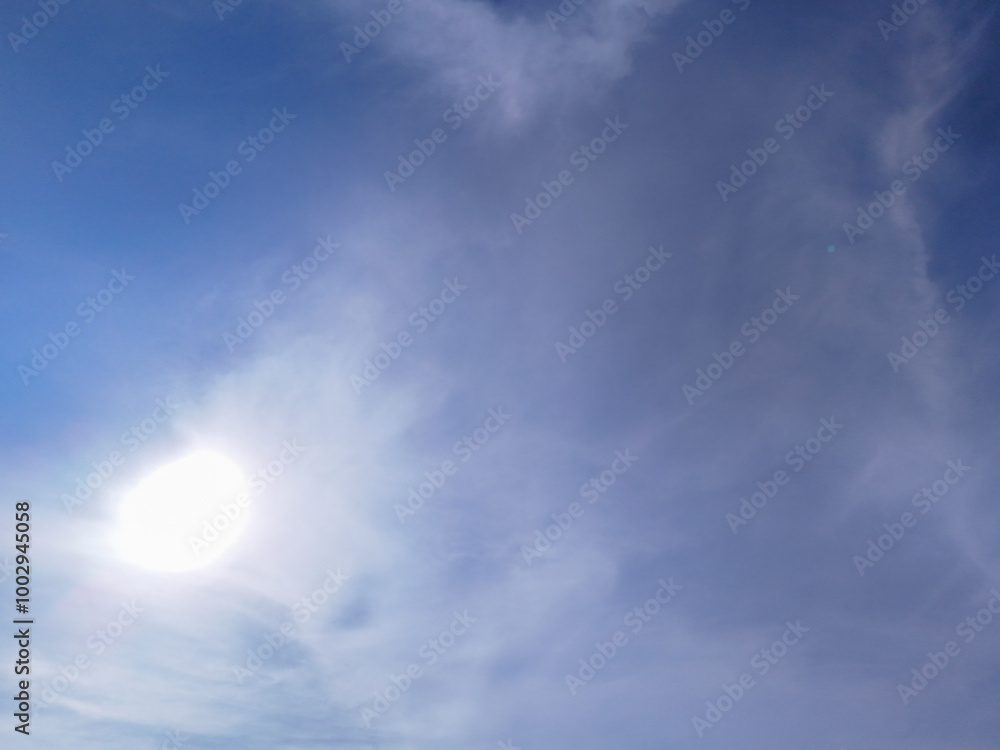 Bright sun shining through light clouds in a clear blue sky, creating a peaceful, serene atmosphere. Ideal for backgrounds due to the soft and natural gradient with sunlight. Bright sun shining through light clouds in a clear blue sky, creating a peaceful, serene atmosphere. Ideal for backgrounds due to the soft and natural gradient with sunlight.