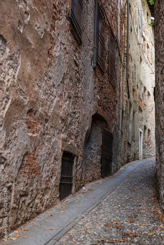 Narrow stone street with medieval brick houses of Citta Alta (Upper Town) in Bergamo, Lombardy region, Italy