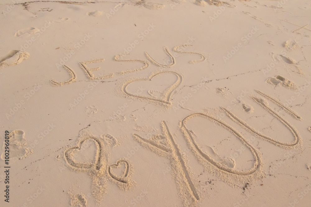 Obraz premium Jesus loves you written in the sand at a beach 